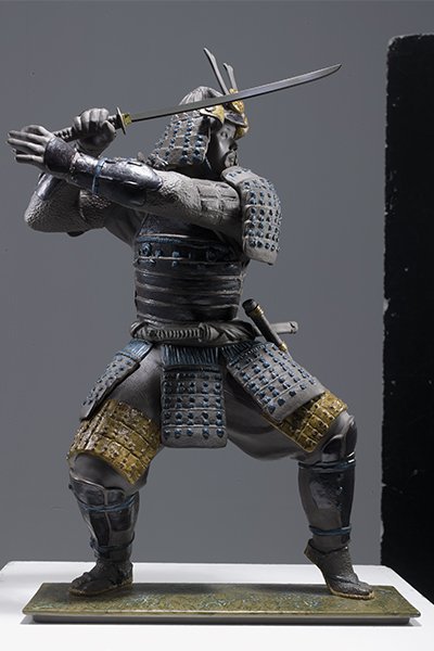 Composición híbrida del proyecto de figuras de cerámica: fotografia real de una figura de ceramica de un guerrero samurai para catálogo y comunicación visual de producto