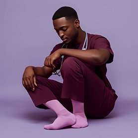 Imagen generada con IA del proyecto de calcetines: enfermero con uniforme granate y calcetines rosa sobre un fondo violeta para e-commerce y comunicación visual de producto